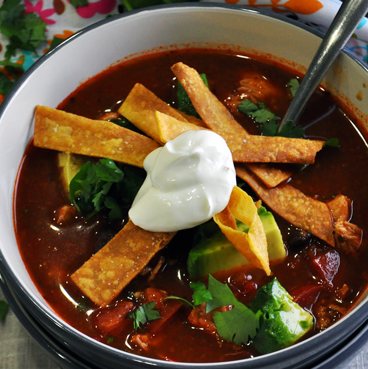 chicken tortilla soup with black beans, chilis, and fried tortilla strips.
