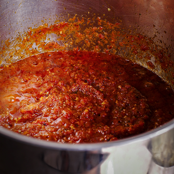 A saucepan filled with homemade marinara sauce.