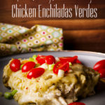 A plate of Chicken Enchiladas Verdes topped with fresh tomatoes and green onions.