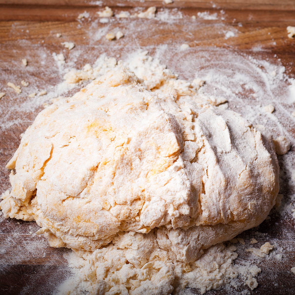 Incorporating more flour into the dough as you knead it.