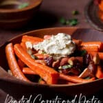 A bowl of roasted carrots and dates topped with roasted almonds and a dollop of labneh cheese.