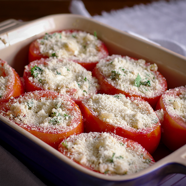 A baking dish filled with cheese stuffed tomatoes ready to be baked.