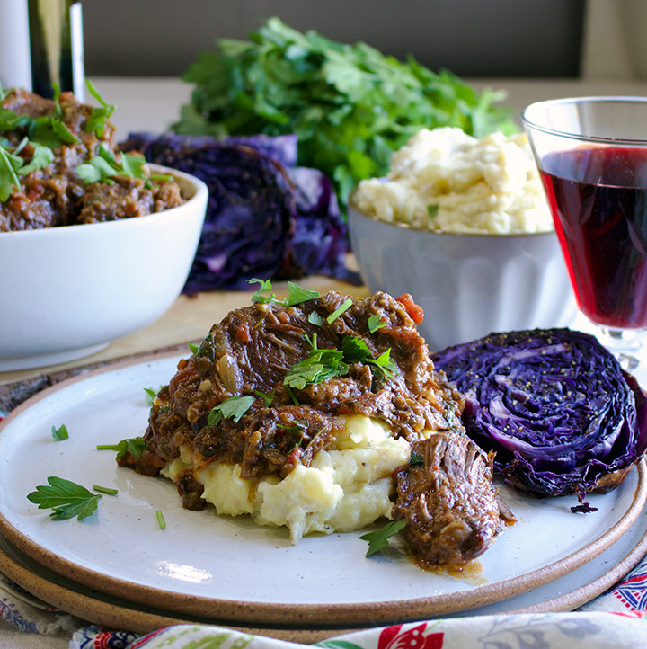 Braised beef in a tuscan vegetable and wine broth over garlic mascarpone mashed potatoes