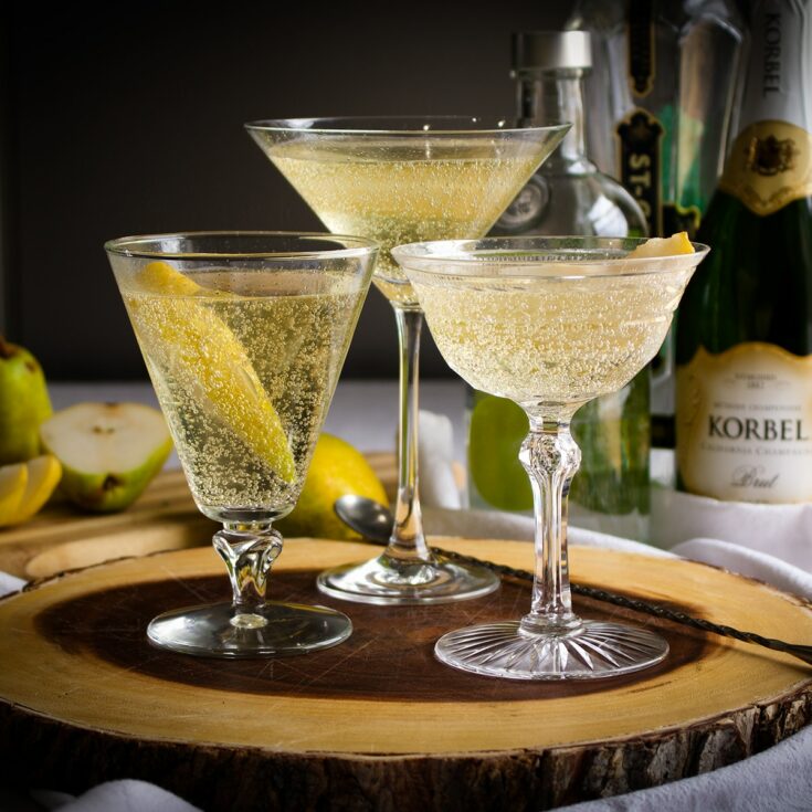 Three French Pear Martinis on a wooden serving platter.