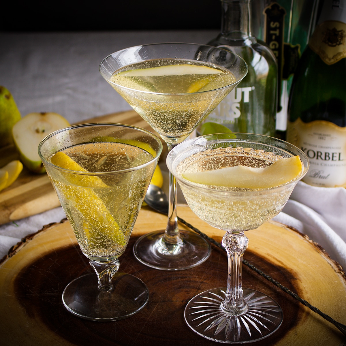 Three French Pear Martinis on a wooden serving platter.
