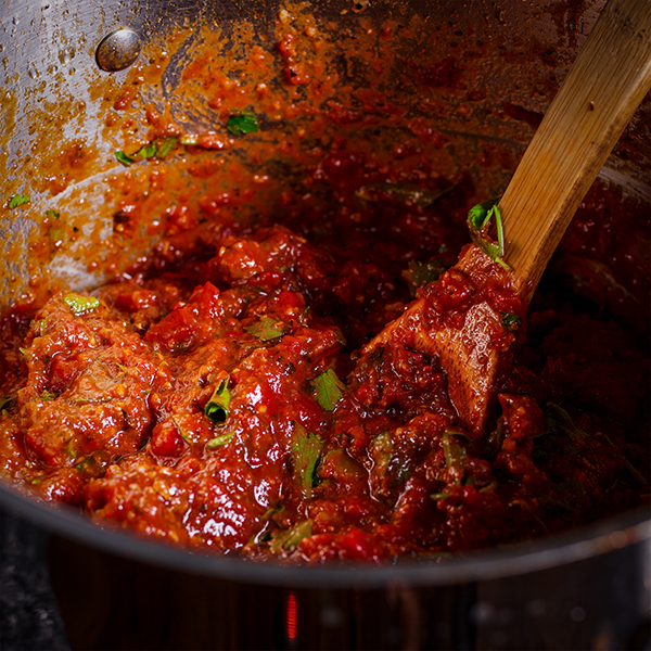 A pot of homemade marinara sauce ready to be added to homemade lasagana.