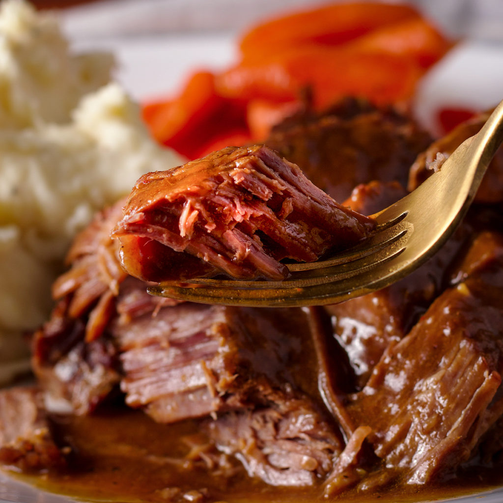 A fork full of cooked Tri-Tip Roast smothered in fennel and coriander gravy.