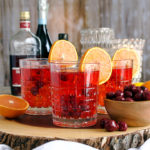A tray with three glasses of Cherry Citrus Prosecco Spritz cocktails.