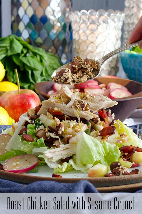 Sprinkling Sesame Crunch on the top of a Roast Chicken Salad with bacon, radishes, and apples.