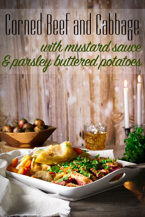 A platter on a table with corned beef and cabbage with mustard sauce and parsley buttered potatoes.