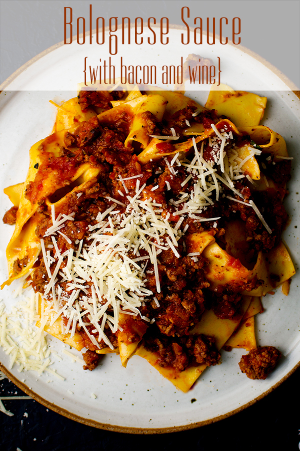 A plate of pasta bolognese with pappardelle pasta and parmesan cheese.