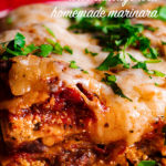 A piece of classic lasagna with homemade marinara and sausage on a plate.