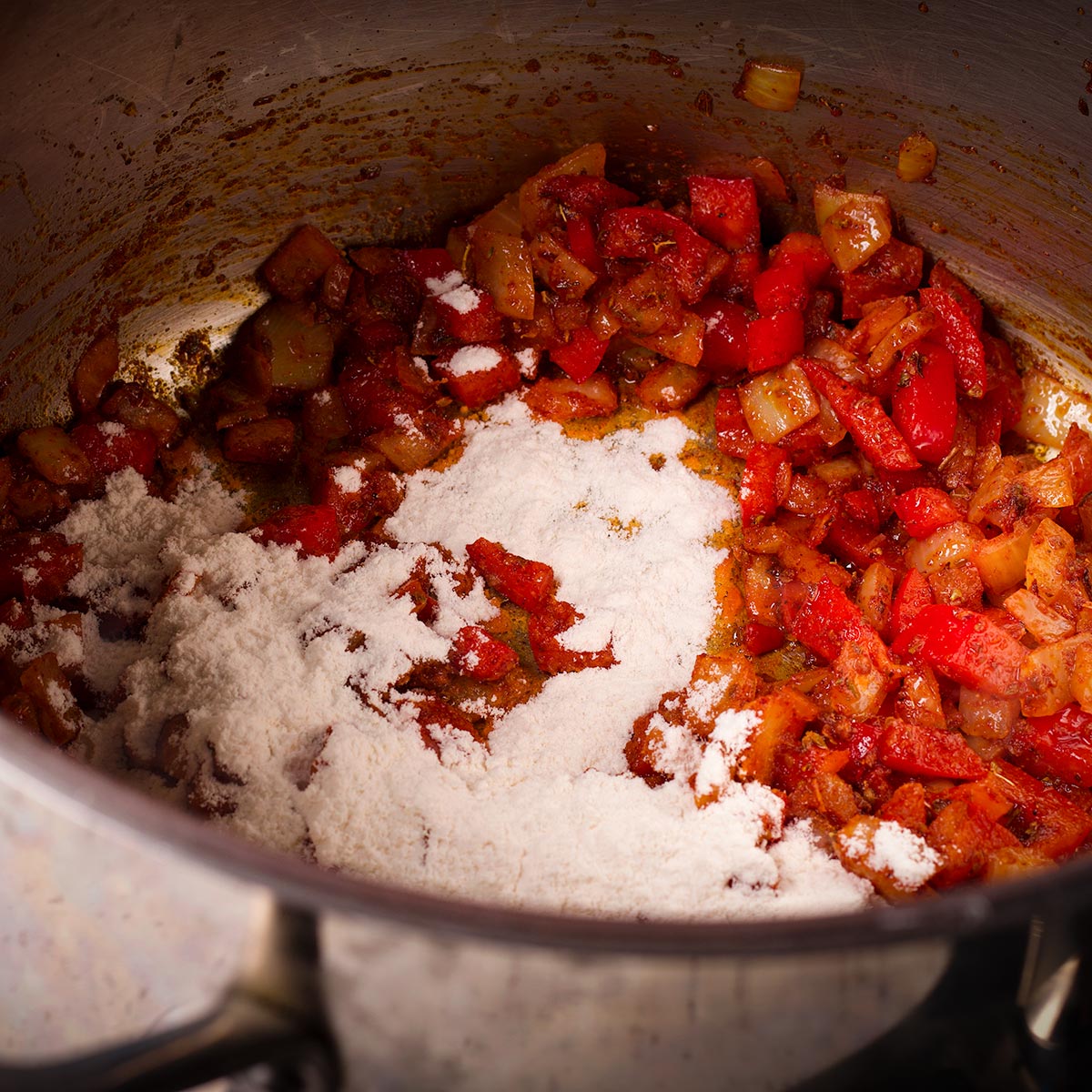 Add some flour to the vegetables and spices in the saucepan and stir to coat everything in the flour.