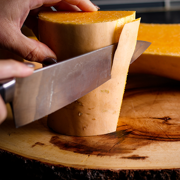 Cutting the peel from a butternut squash.