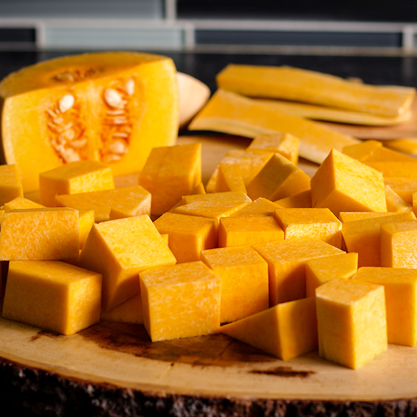 A butternut squash that's been partially peeled and chopped.