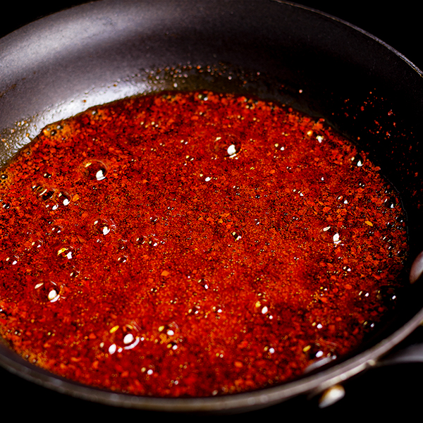 Cooking crushed Aleppo pepper in olive oil before drizzling it over bowls of Red Lentil Soup.