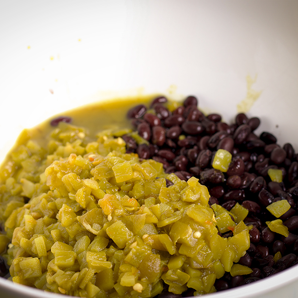 A bowl of chopped green chilies and black beans.