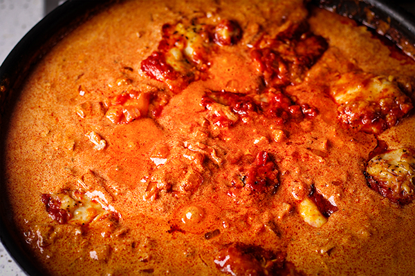 A pan of Chicken Paprikash cooking on the stovetop.