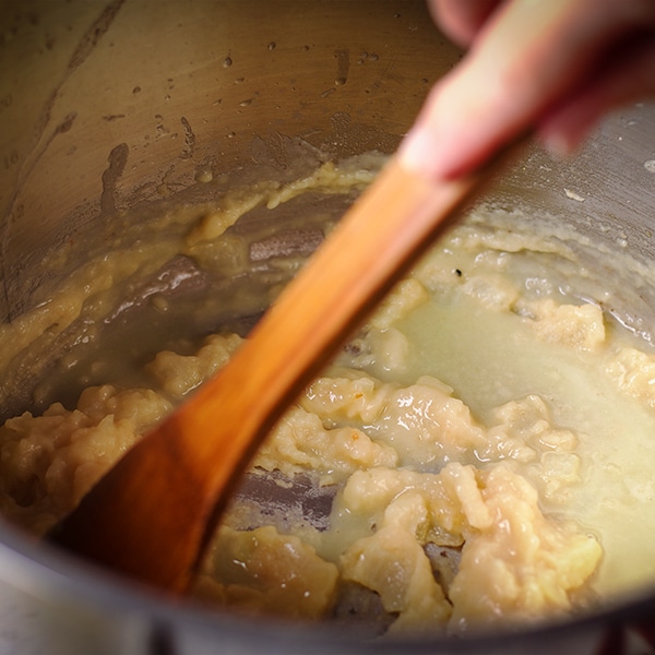Using a wooden spoon to cook flour and butter to make a roux.