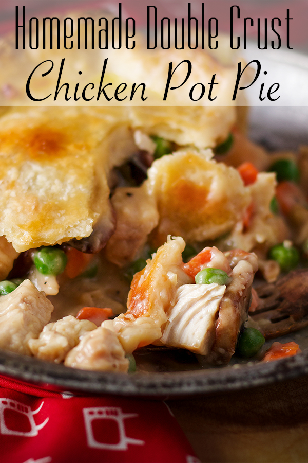 A piece of classic double crust chicken pot pie on a plate with a fork.