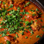 A pan of Chicken Paprikash sprinkled with chopped, fresh parsley.
