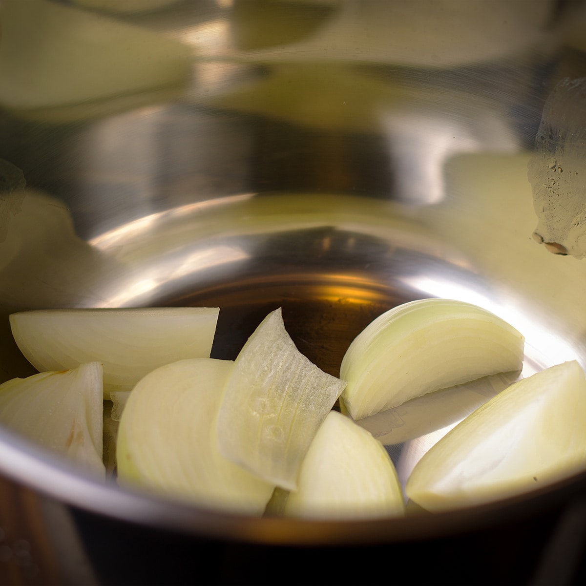 Slices of onion in the bowl of an instant pot.