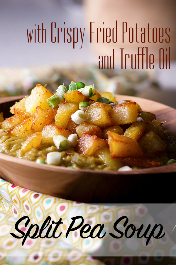 A bowl of split pea soup with ham, topped with crispy fried potatoes and sliced green onions.