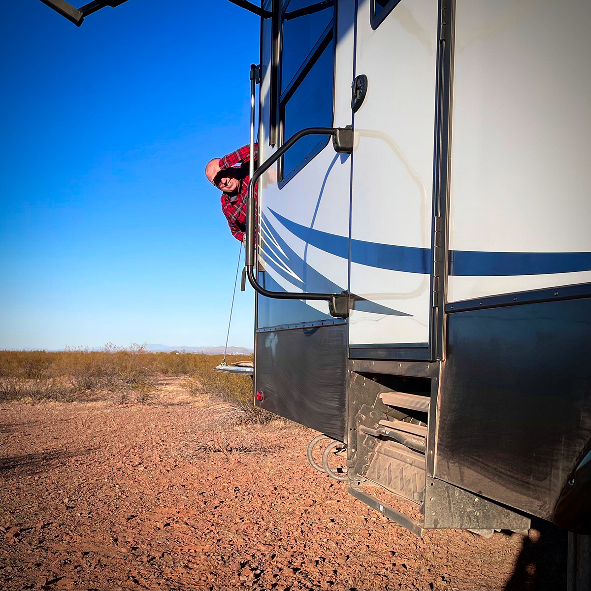 Steve peaking around the back of our RV in the Arizona desert.