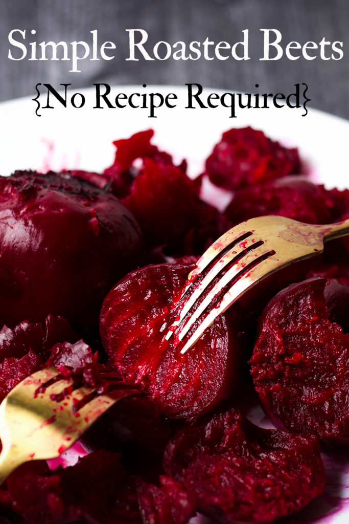 Someone using two forks to pull apart tender roasted beets. 