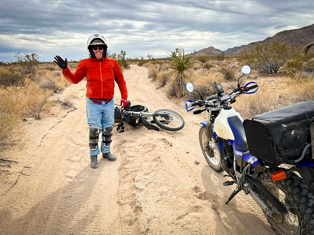 Steve standing next to his dual sport bike after laying it down in the dirt in California.