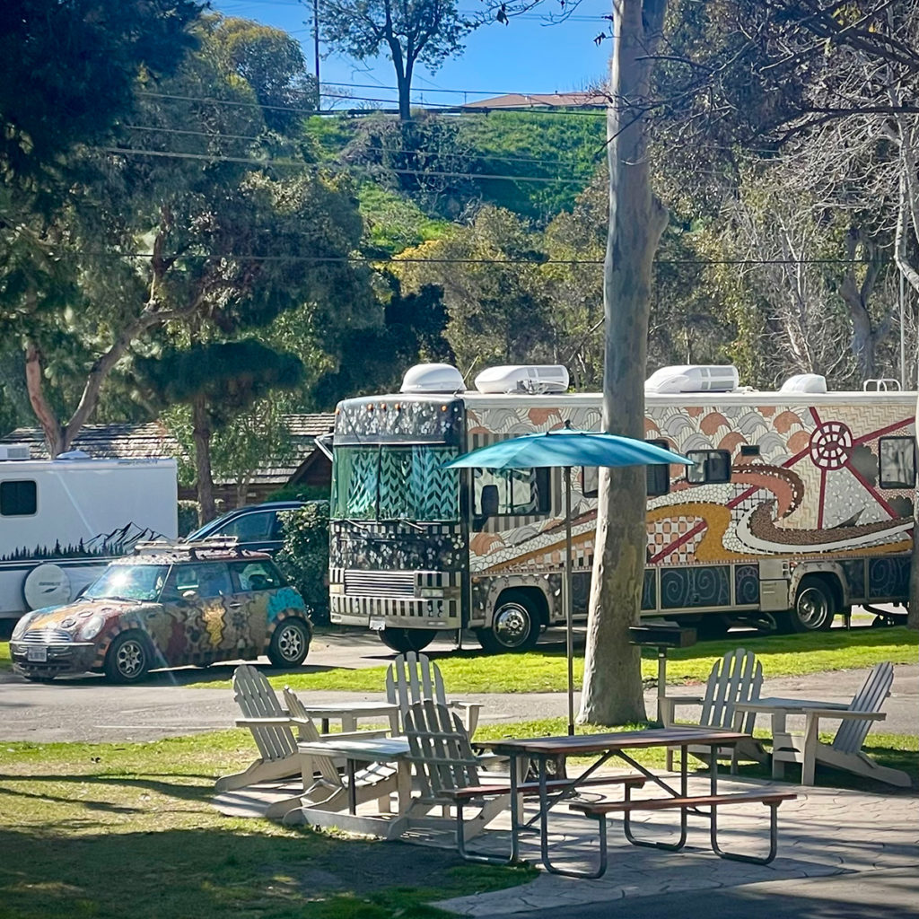 An artistically decorated RV and car parked in a space at the San Diego Metro KOA.