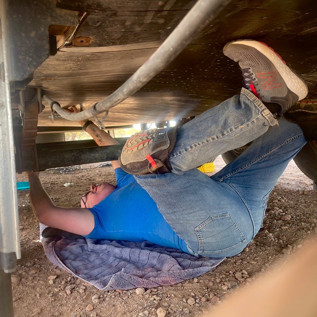 A photo of Steve laying on his back underneath our RV to make repairs.