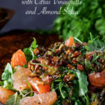 A large plate piled high with a generous portion of salmon salad with citrus vinaigrette and almond salsa.