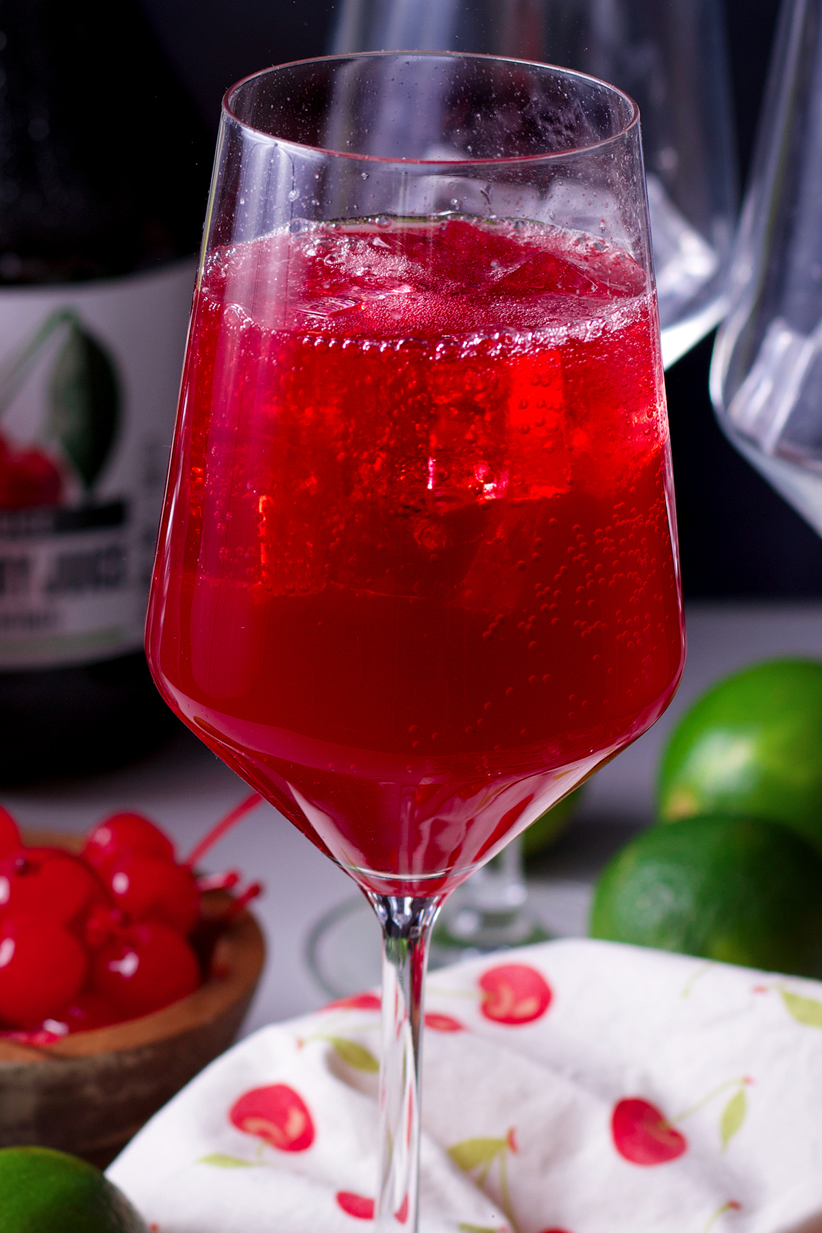 A glass filled with vodka, cherry juice, grenadine, and lime juice that's just been topped with lemon lime soda.