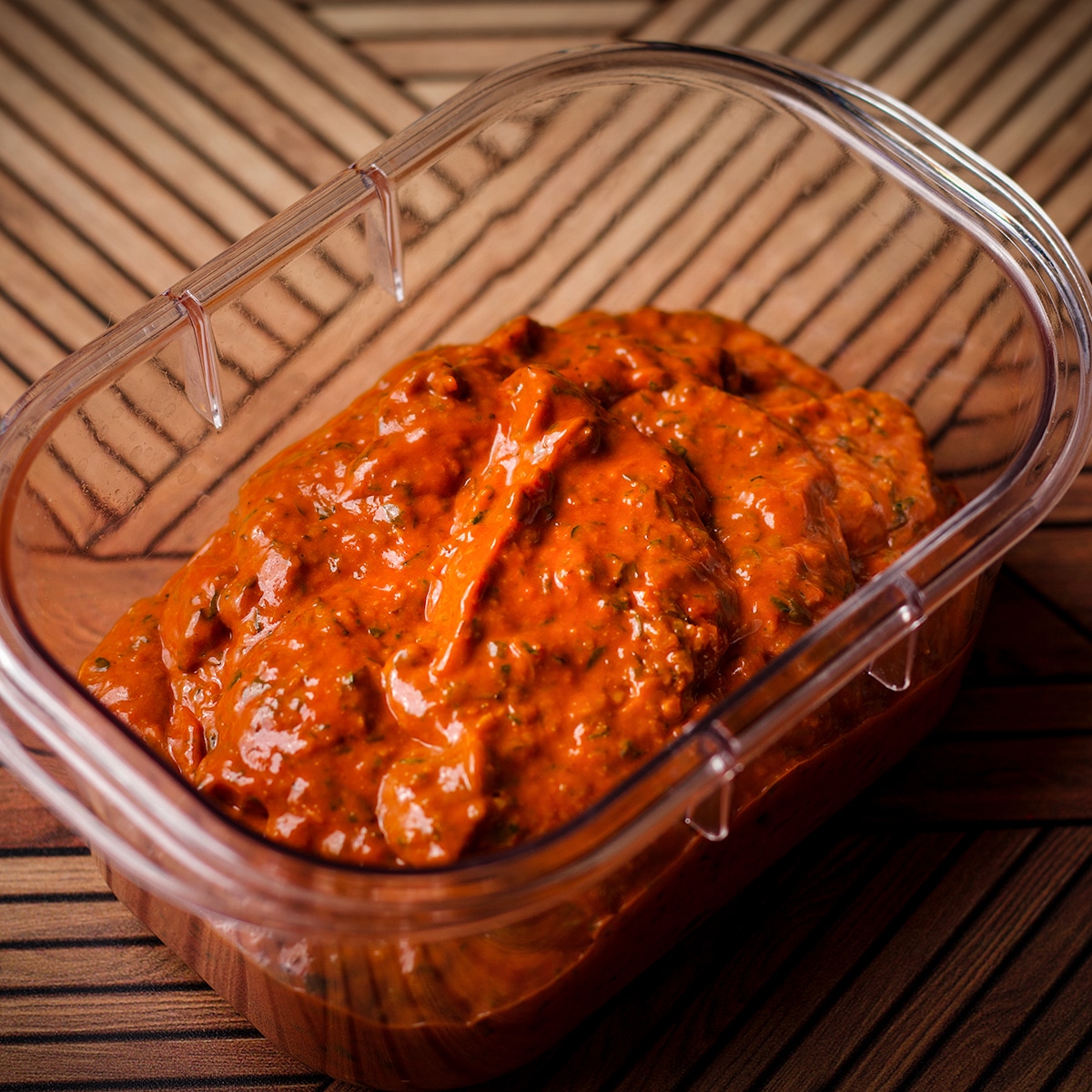 A small, clear plastic bowl that contains homemade Mexican Adobo.