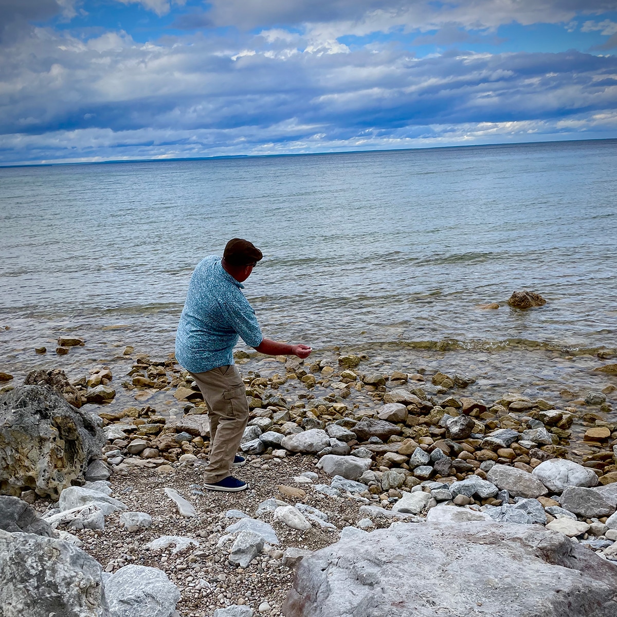 Steve skipping rocks in Lake Michigan from a rocky beach on Mackinac Island.