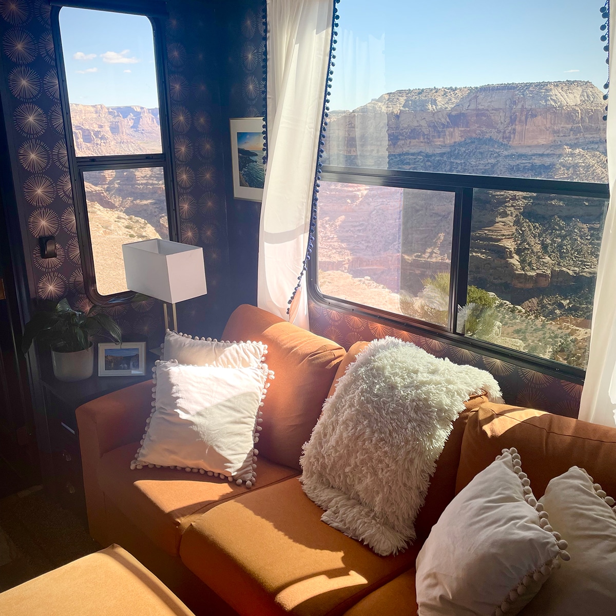 The living room area inside our RV with a gorgeous view of the Little Grand Canyon outside the window behind our sofa.