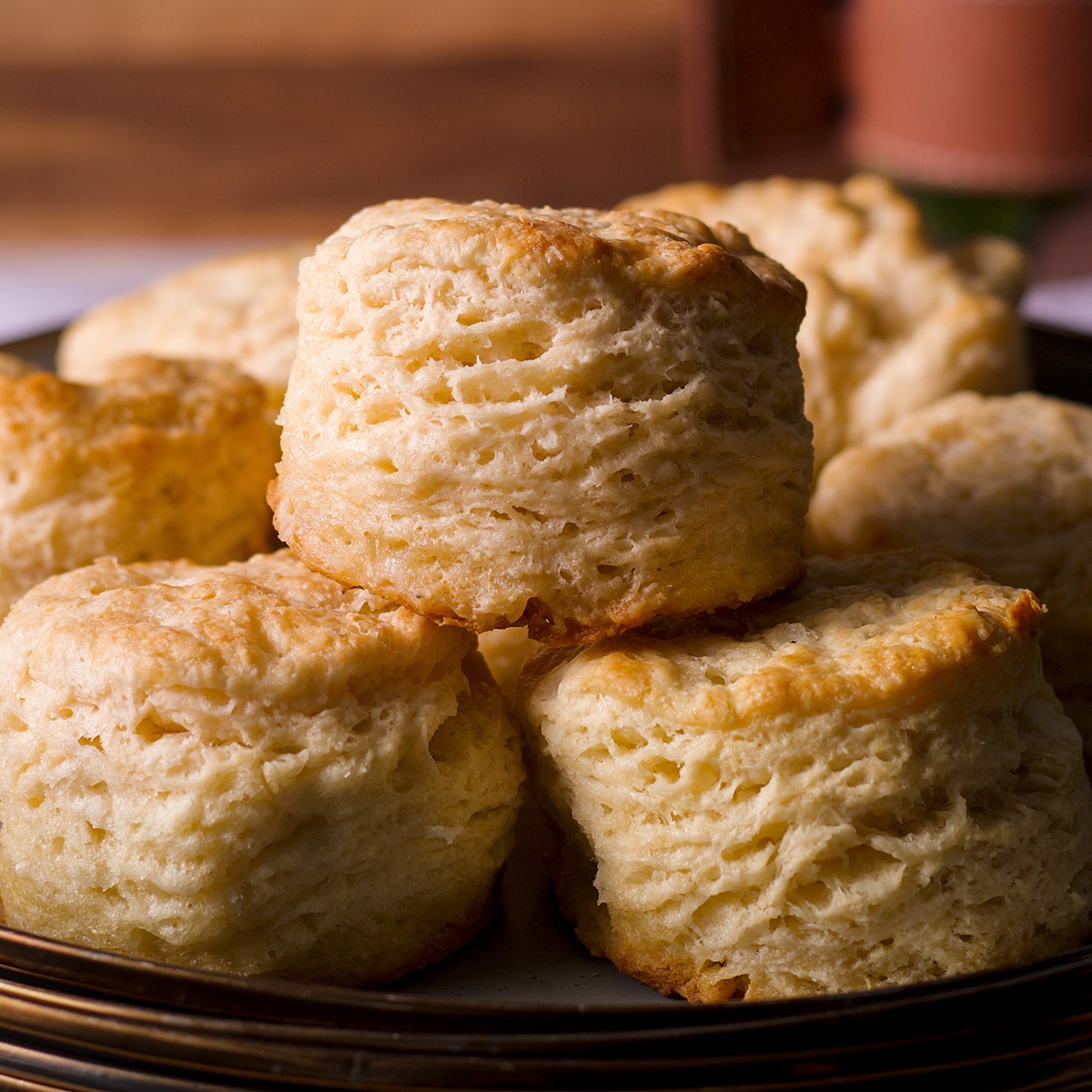 A plate piled high with warm homemade buttermilk biscuits.