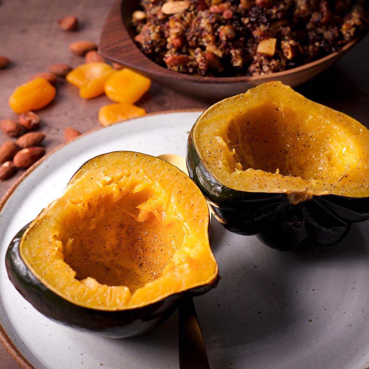 An acorn squash that's been cut in half and set, cut side up, on a white plate.