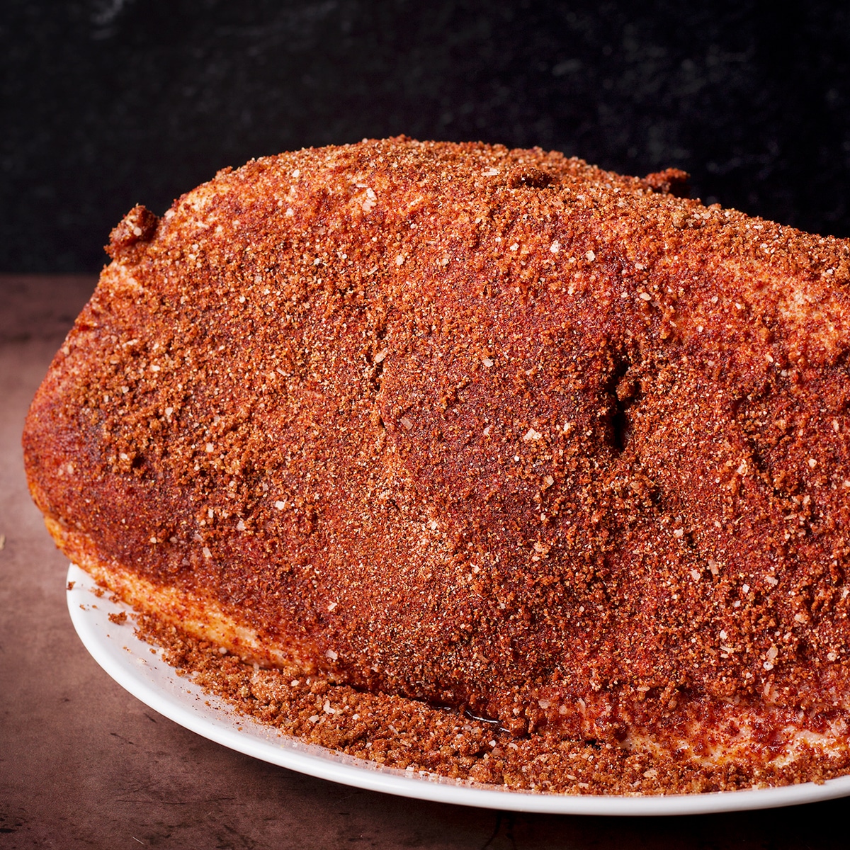 A pork roast that's been covered on all sides with a dry rub.