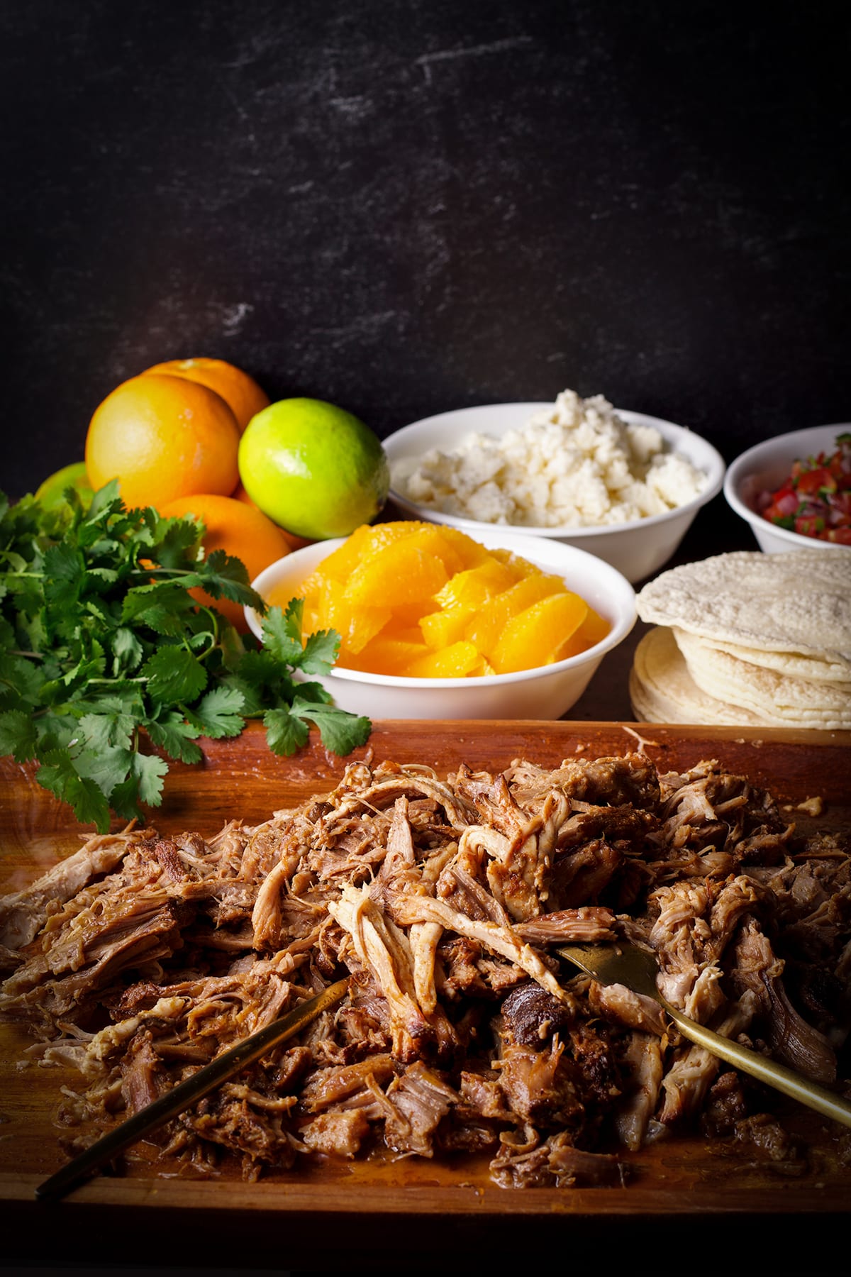 A wood tray filled with shredded pork for tacos.