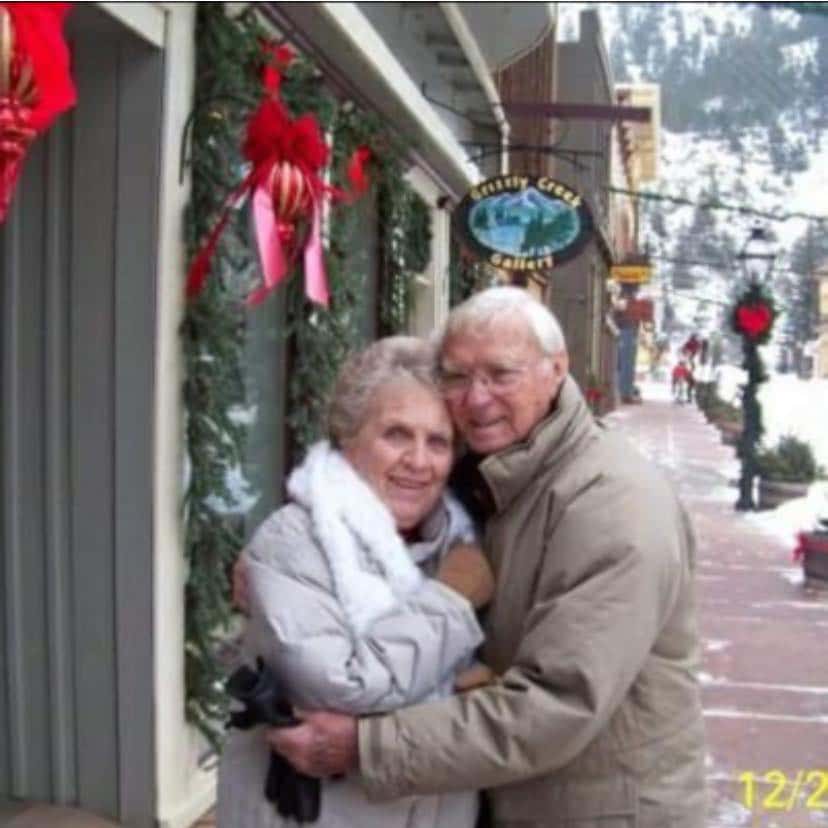 My grandparents standing in downtown Estes Park during the holiday season with all the shops decorated for Christmas.
