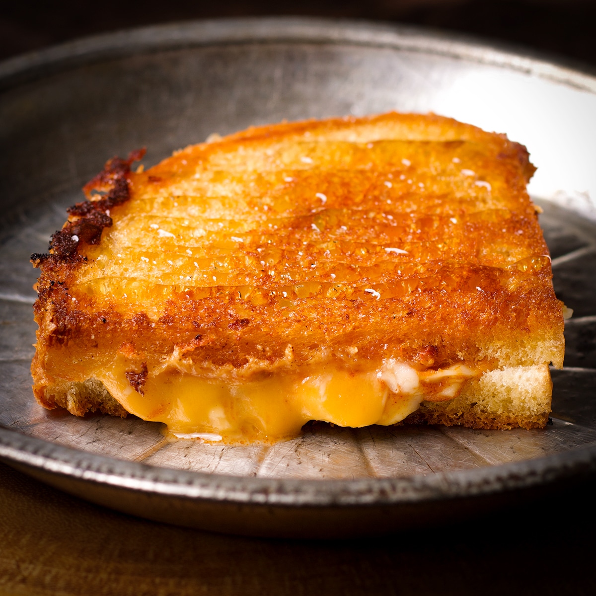 A miso butter grilled cheese sandwich on a tin plate.