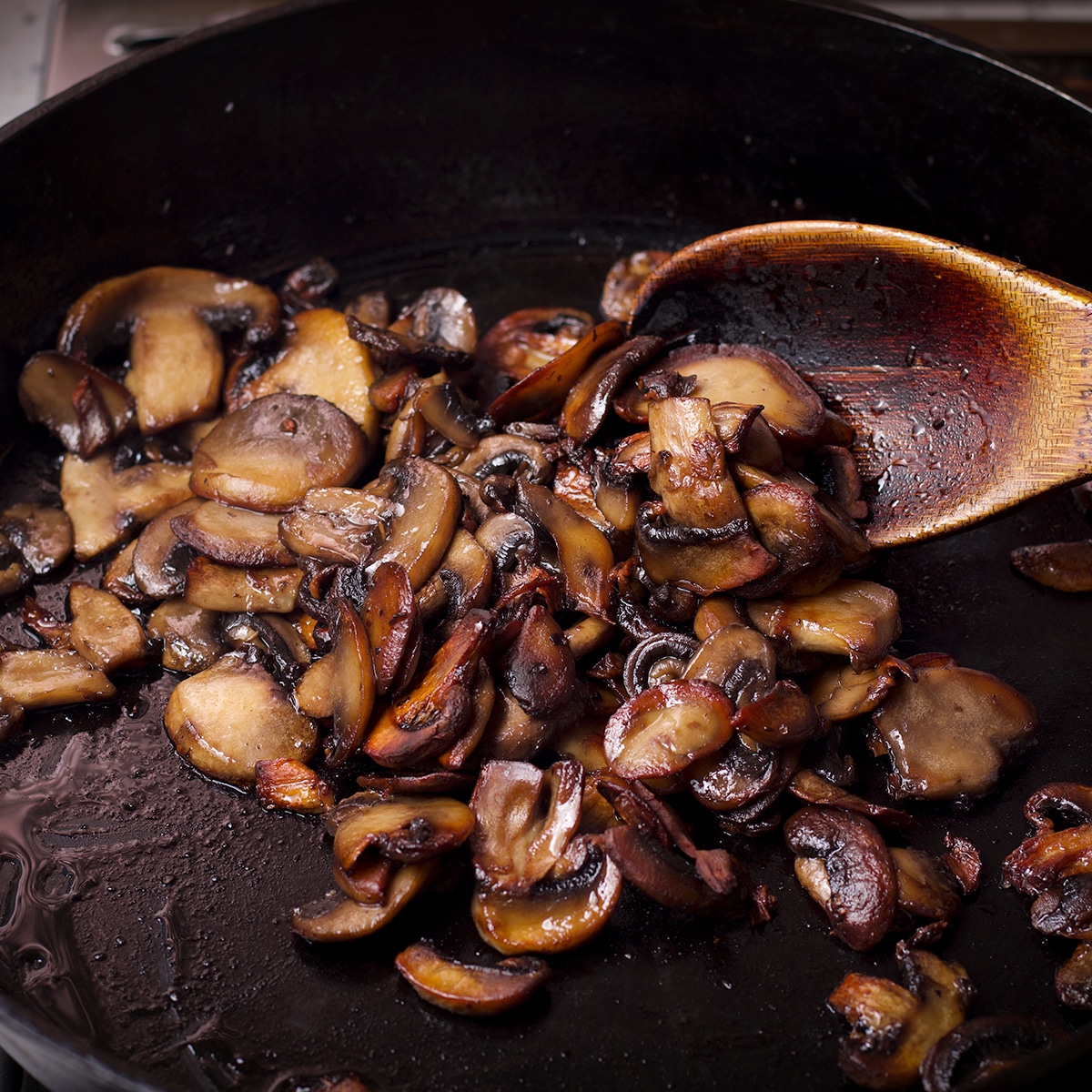 Cooking sliced mushrooms in a skillet until golden and caramelized.