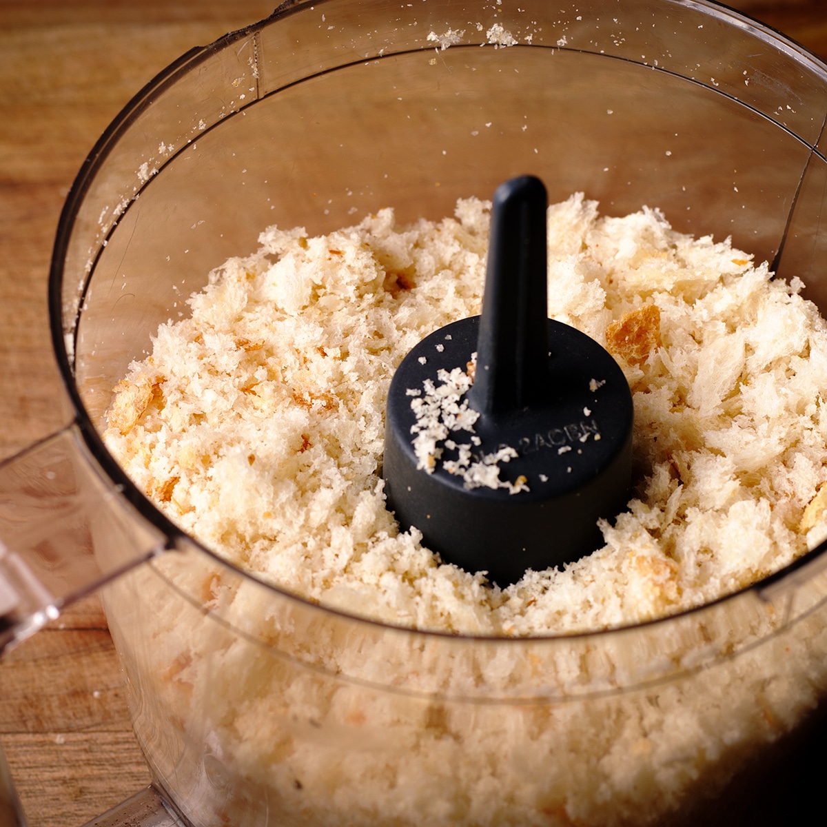 Pulsing slices of bread and garlic in a food processor to make fresh bread crumbs.