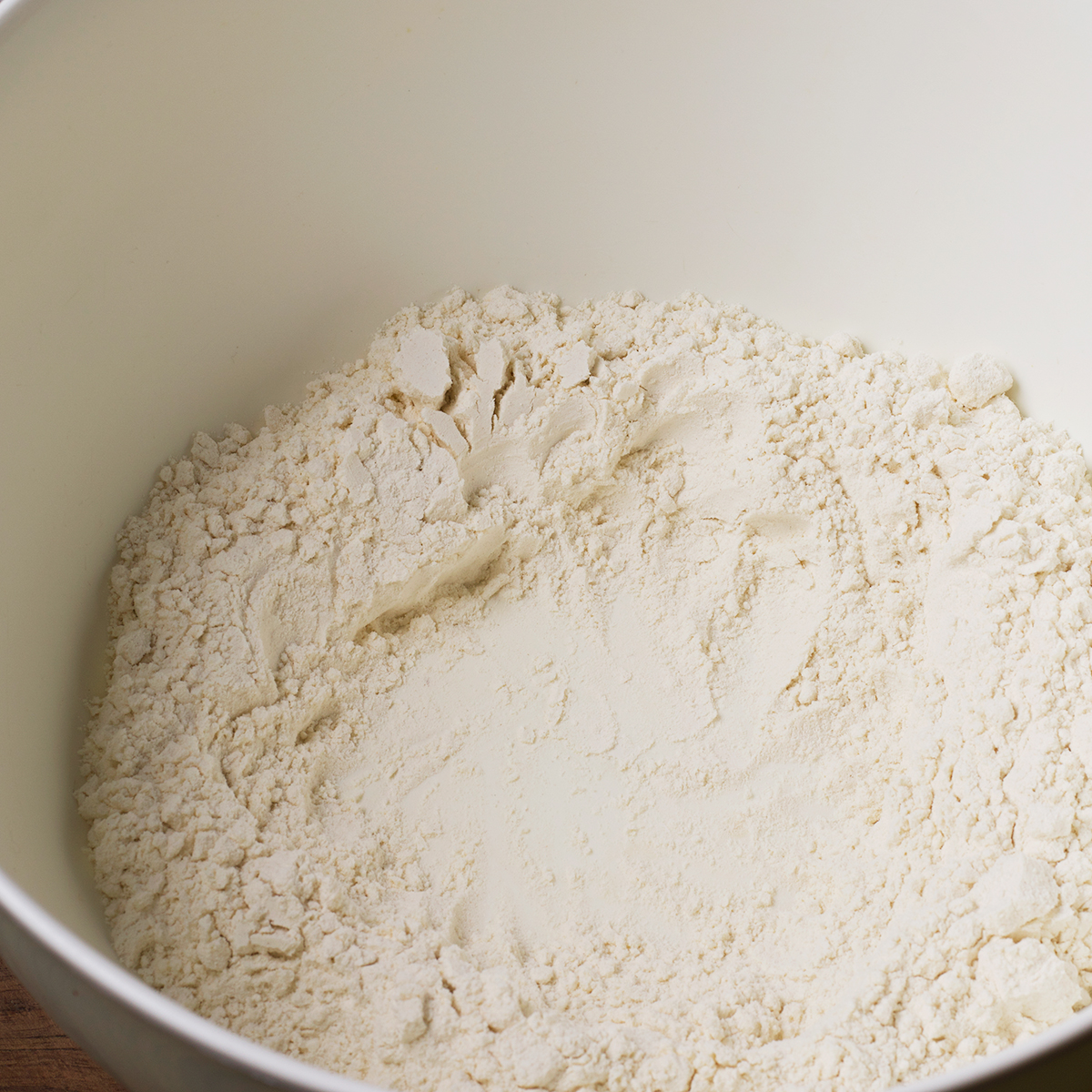 Flour in a bowl with a well in the center for egg yolks.