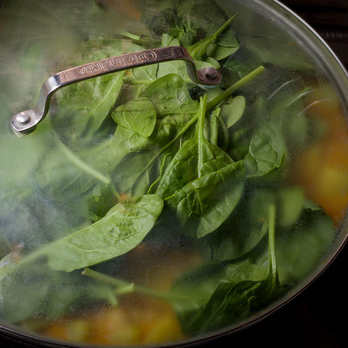 Cover the pan with a lid after adding fresh spinach to encourage the spinach to wilt.