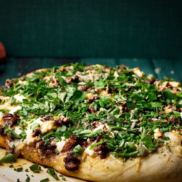 A homemade mushroom pizza topped with truffle oil and fresh herbs.