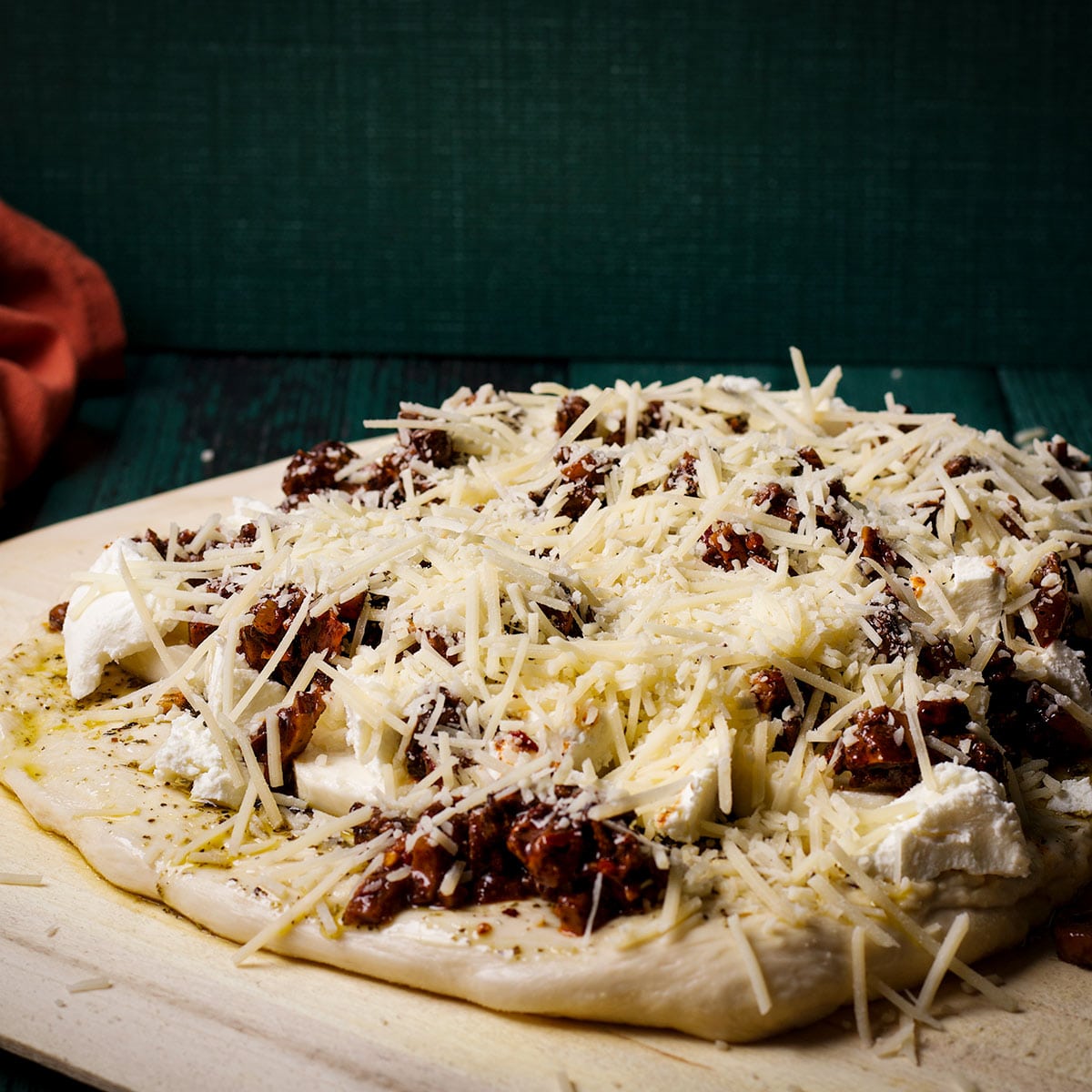 Sprinkle grated or shredded parmesan cheese over the mushroom ragu on the pizza.