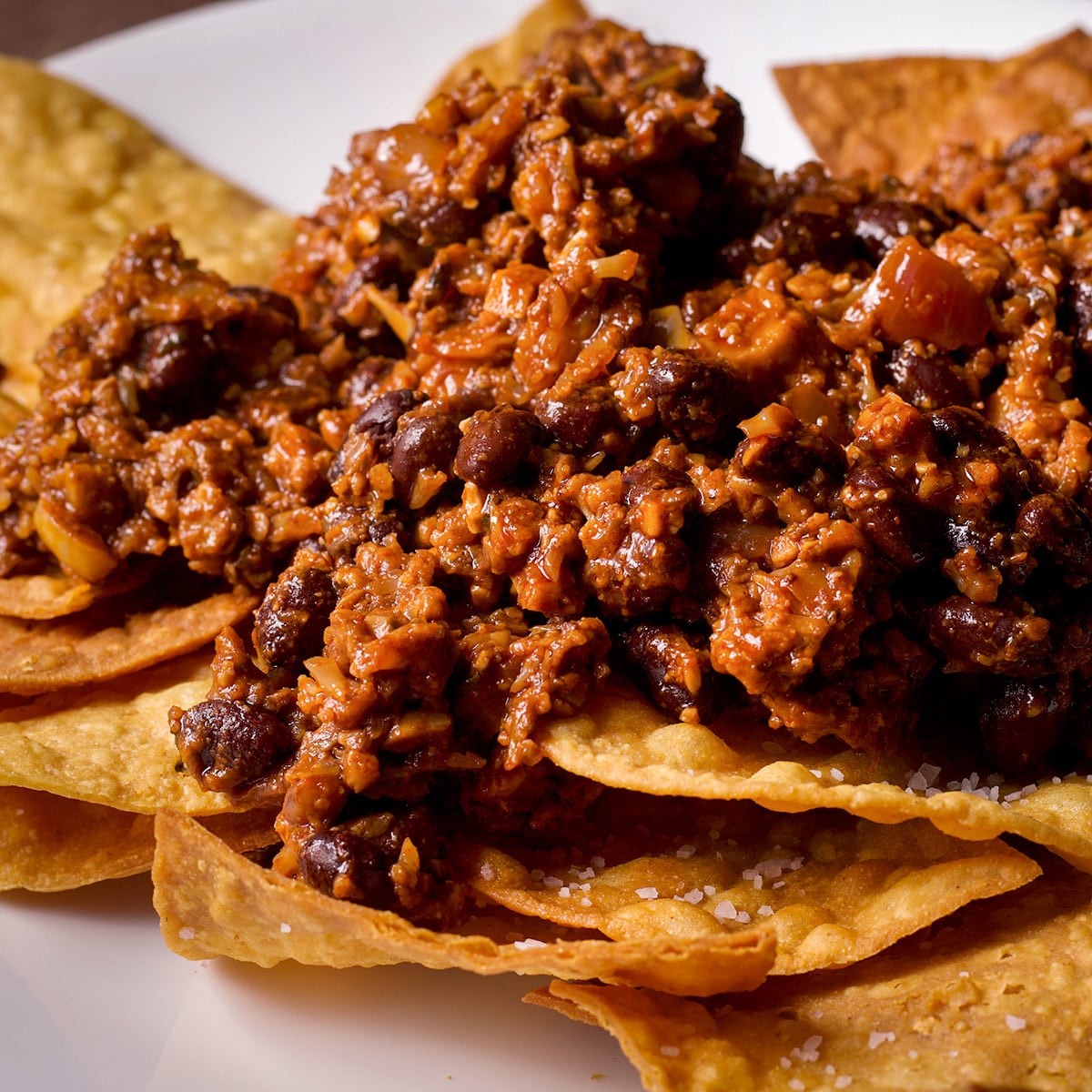 Vegan taco meat piled onto tortilla chips.